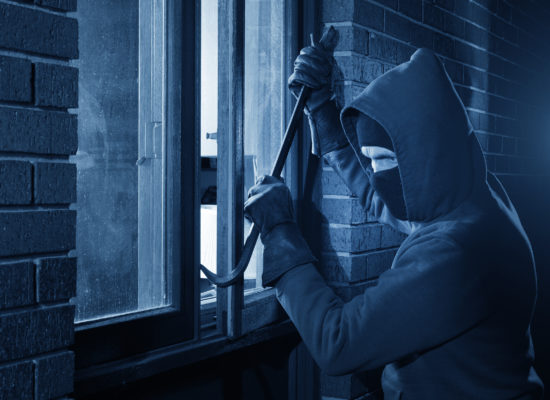 Burglar Using Crowbar To Break Into a House at night with room l